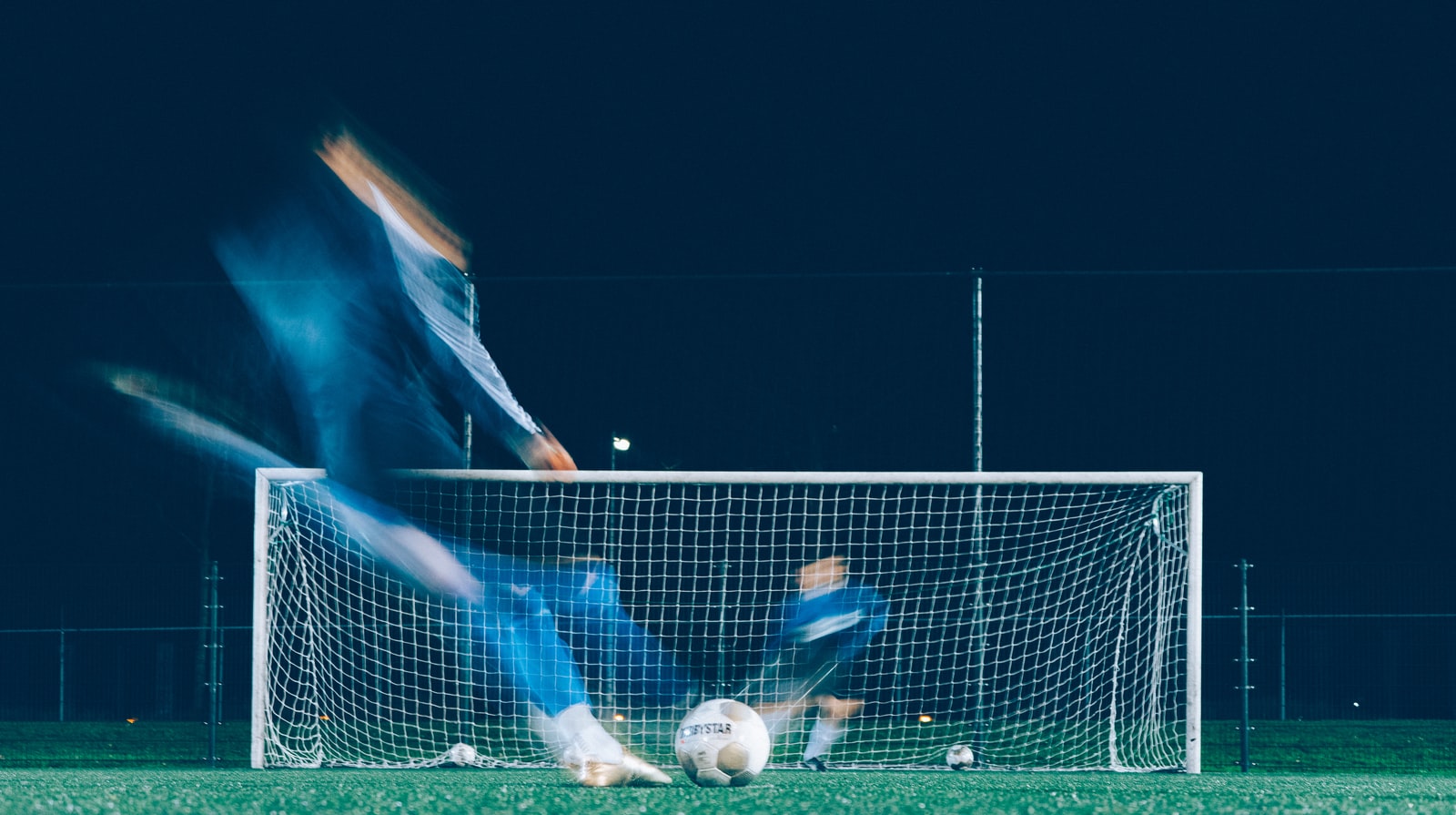 timelapse photo of soccer player kicking ball