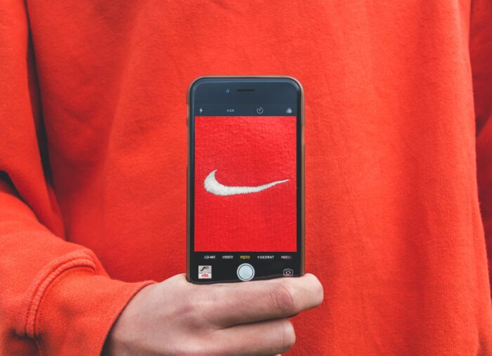 person holding AR Nike Metaverse Logo on phone