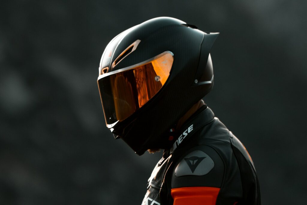 black and orange helmet on black motorcycle