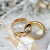 gold wedding band on white textile